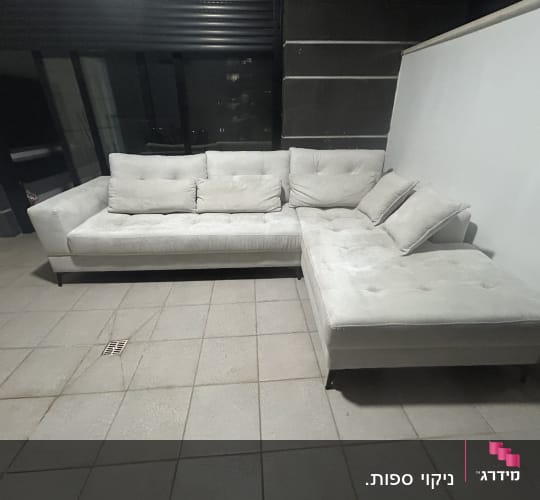 ספה בהירה על מרפסת מרוצפת בלילה